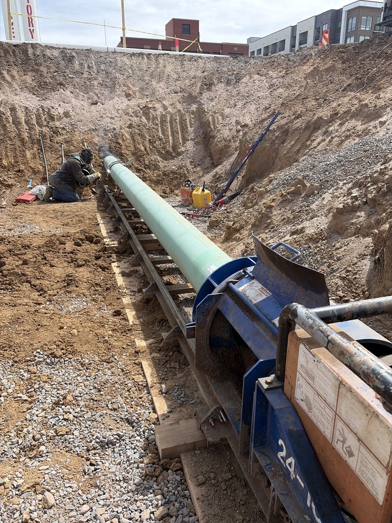 Pit launch boring equipment aligned with pipe in an excavation